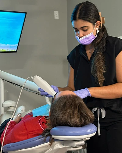 Dental professional performing teeth whitening procedure in Tampa, FL office